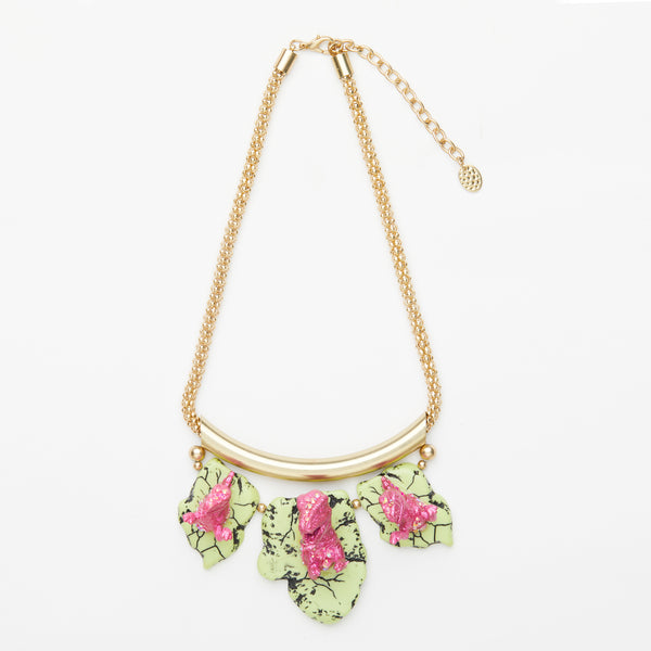 pink dinosaur necklace on yellow stones